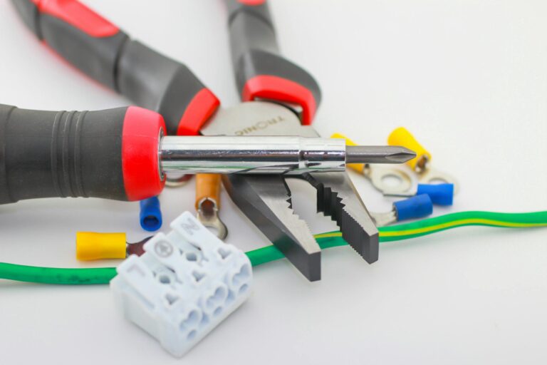 A detailed close-up of hand tools including a screwdriver and pliers with various wiring accessories.