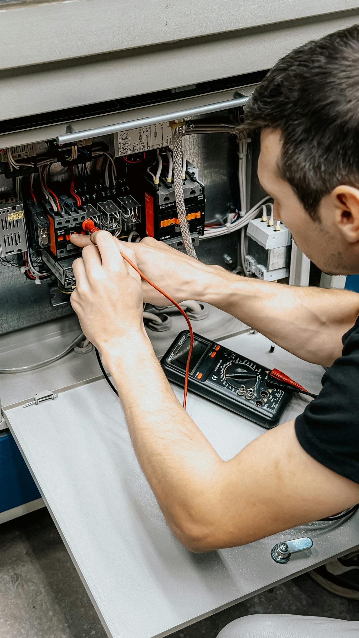 An Electrician Uses A Multimeter To Test