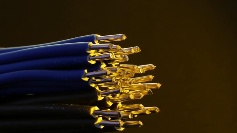 Detailed view of blue ethernet cables with exposed gold-plated conductors.